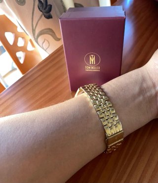 Reloj de pulsera dorado con detalles brillantes