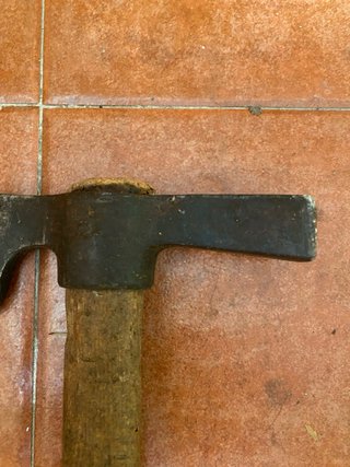 Hacha antigua de metal y madera
