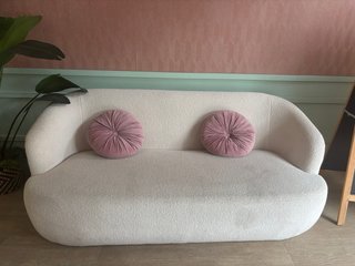 Sofá de tela blanco con cojines rosas