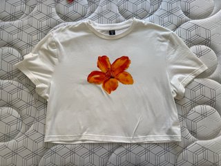 Camiseta blanca con flor naranja