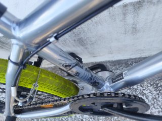 Bicicleta BMX plateada con ruedas verdes