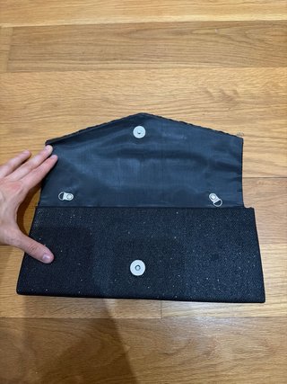 Bolso de mano negro brillante.