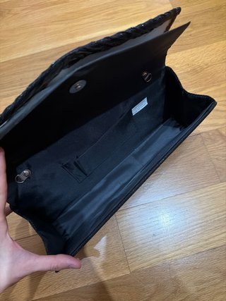 Bolso de mano negro brillante.