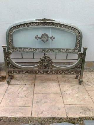 Cama antigua de metal y cristal tiene los larguero