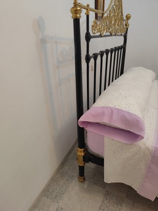 Cama antigua de hierro y forja dorada