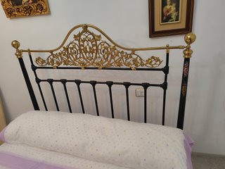 Cama antigua de hierro y forja dorada