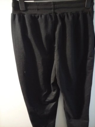 Pantalón negro con estampado de cara triste