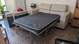 Sofá cama beige con puf