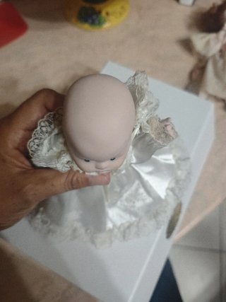 Bambola in porcellana con vestito bianco
