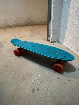 Skate azul con ruedas naranjas