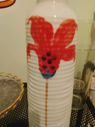 Jarrón de cerámica blanco con flor roja