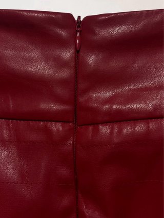 Talla S. Minifalda roja efecto piel de BERSHKA.