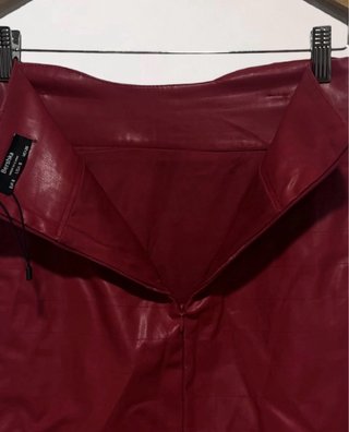 Talla S. Minifalda roja efecto piel de BERSHKA.