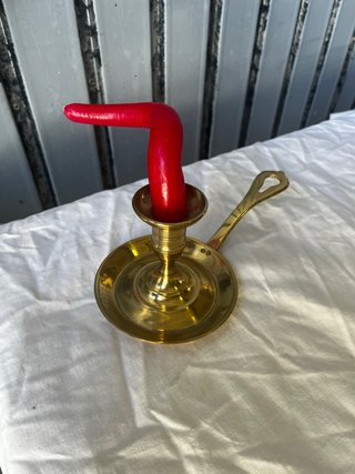 Candelabro de bronce con vela roja