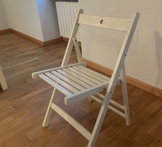 Silla plegable blanca con cojín a rayas