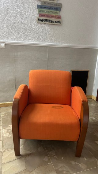 Sillón naranja con estructura de madera