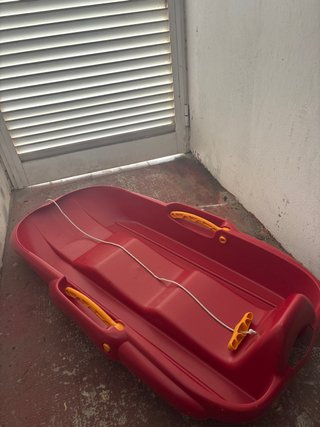 Trineo de plástico rojo con cuerda