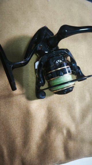 Carrete de pesca negro con hilo verde