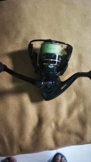 Carrete de pesca negro con hilo verde