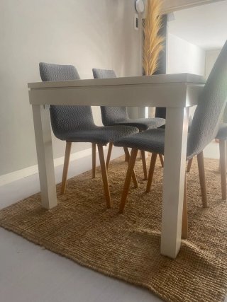 Mesa de comedor blanca con tapa de cristal.