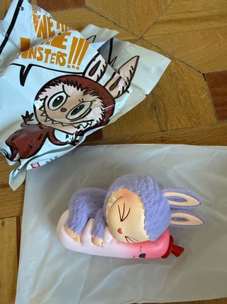 Labubu peluche durmiendo en botella rosa