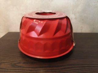 Forma de bolo vermelha com  furo no centro