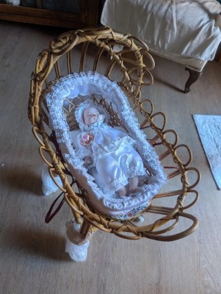 Cuna mimbre con muñeco bebé