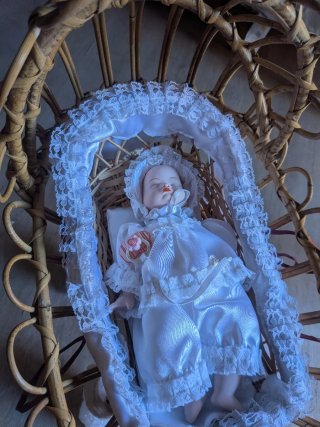 Cuna mimbre con muñeco bebé