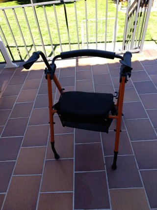 Andador naranja con asiento y ruedas