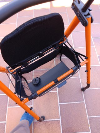 Andador naranja con asiento y ruedas