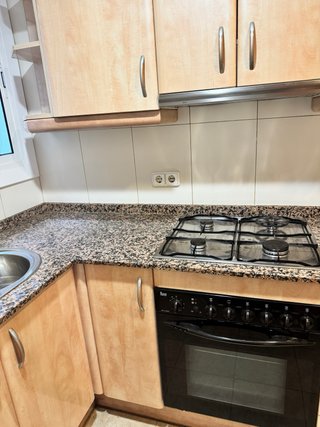 Cocina en L de madera y piedra