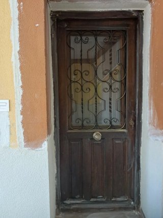 Puerta antigua de madera con reja