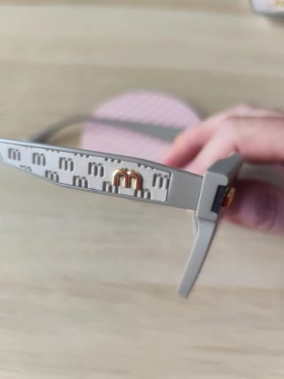 Occhiali da sole grigi con dettagli dorati Miu Miu