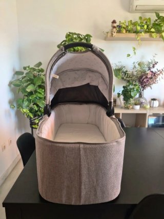 Carro de bebé Kinderkraft gris con capazo y bolso.