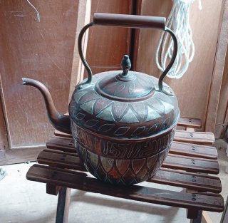 Cafetera antigua de metal con detalles dorados
