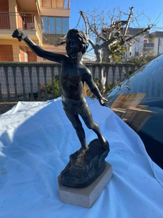 Statua in bronzo di ragazzo su roccia