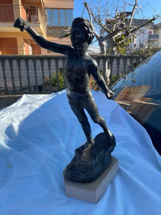Statua in bronzo di ragazzo su roccia