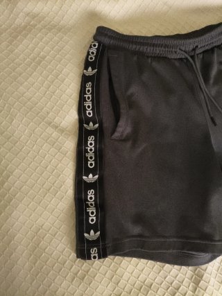 Pantalón corto Adidas gris oscuro, con bolsillos.
