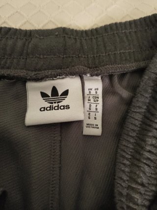 Pantalón corto Adidas gris oscuro, con bolsillos.