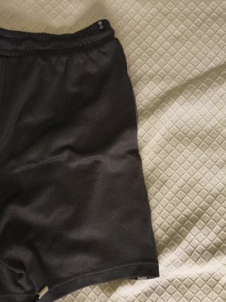 Pantalón corto Adidas gris oscuro, con bolsillos.