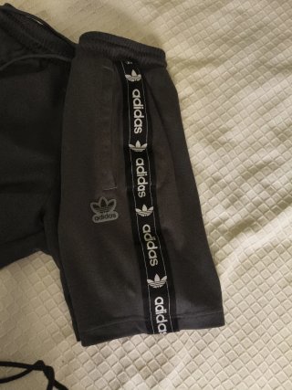 Pantalón corto Adidas gris oscuro, con bolsillos.