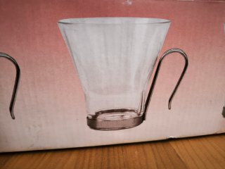 Tazas de cristal con asa metálica.