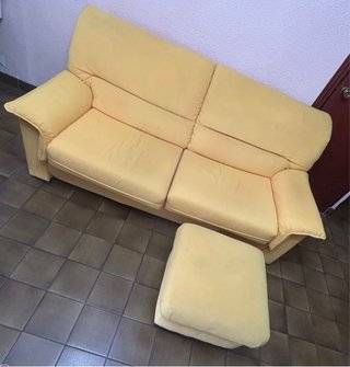 Sofá amarillo de tela con otomana