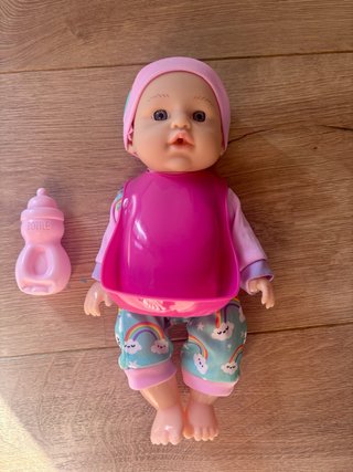 Muñeca bebé con biberón y babero