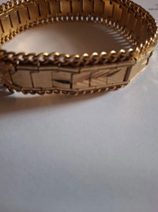 Pulsera dorada con diseño grabado