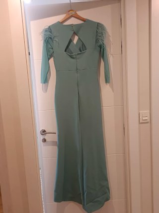 Vestido aguamarina boda con plumas en los hombros.
