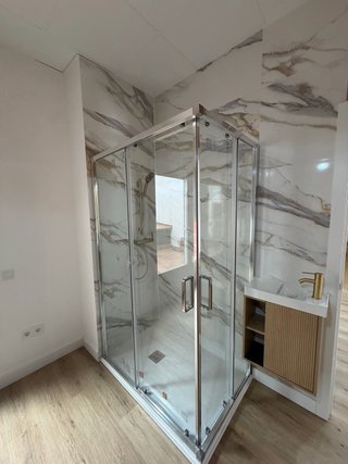 Baño reformado azul y mármol
