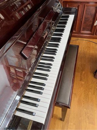 Piano de madera oscura con banqueta