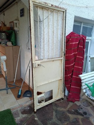 Puerta de exterior de hierro con reja y cristal