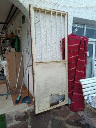 Puerta de exterior de hierro con reja y cristal